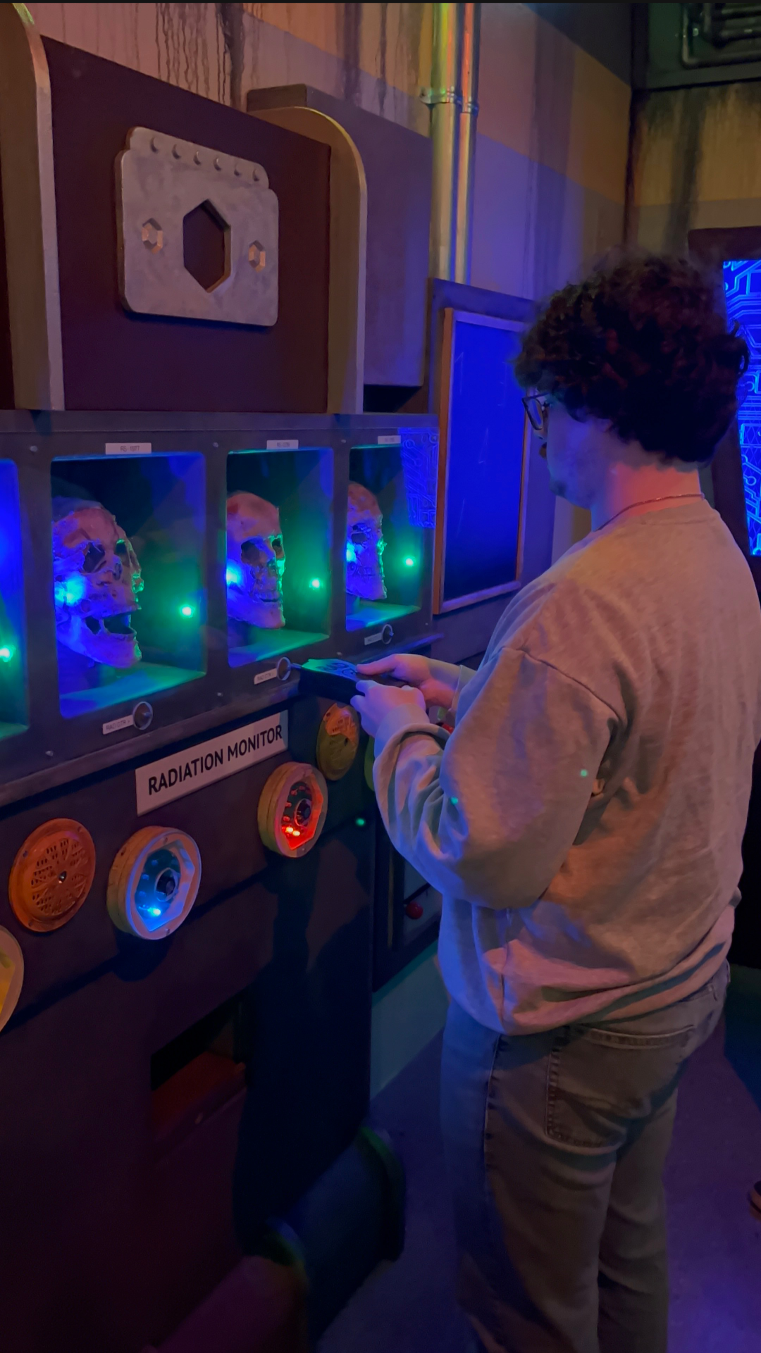 A player scans glowing skulls at the Radiation Monitor panel inside the Vault 1033 escape room